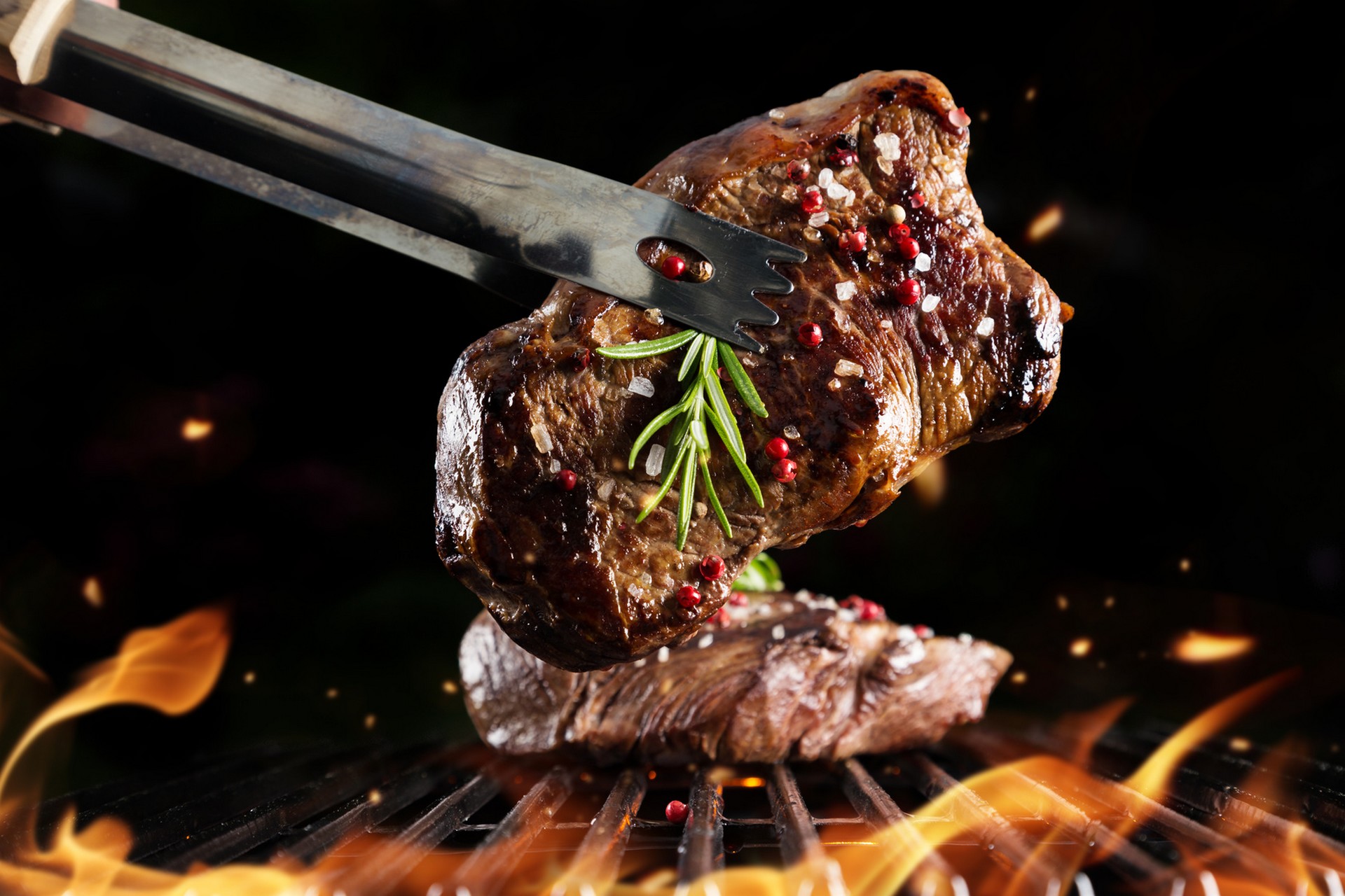 Beef steak on grill, isolated on black background